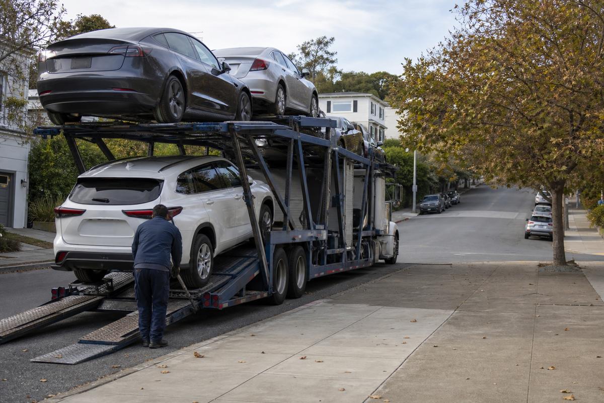 Car shipping in Berkeley An open auto carrier unloading on a residential street