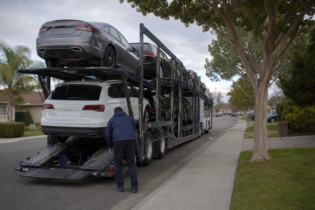 Car shipping in Santa Clara An open auto carrier unloading on a residential street