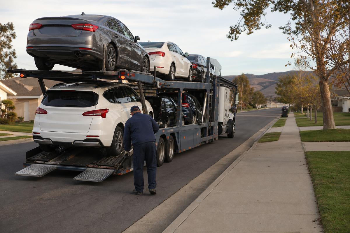 Car shipping in Santa Maria An open auto carrier unloading on a residential street