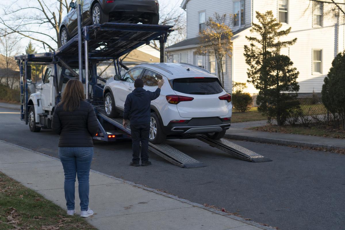 Car delivery in Worcester An SUV being driven down the ramps off an open carrier at delivery