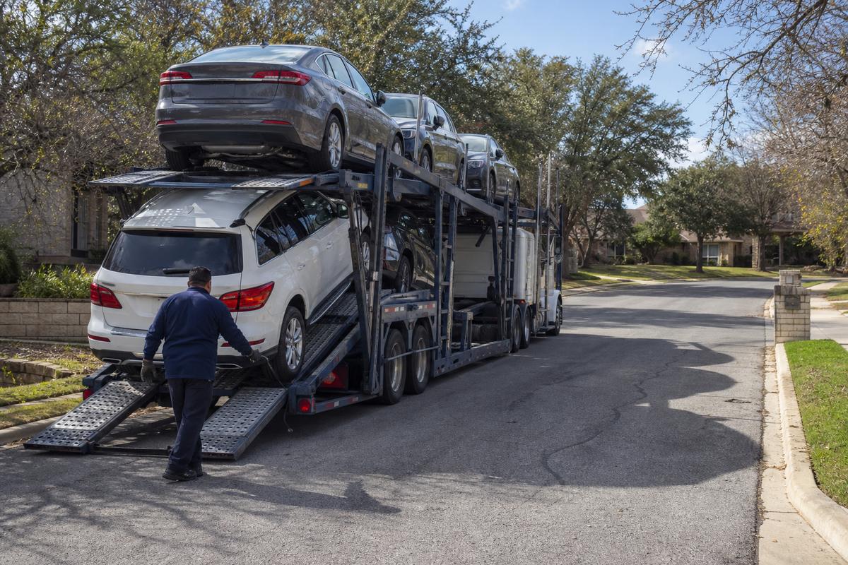 Car shipping in New Braunfels An open auto carrier unloading on a residential street