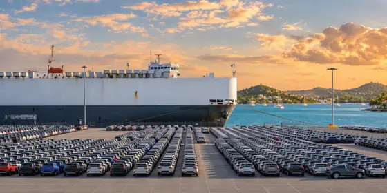 A car ship and a vehicle lot at a Caribbean port at sunset