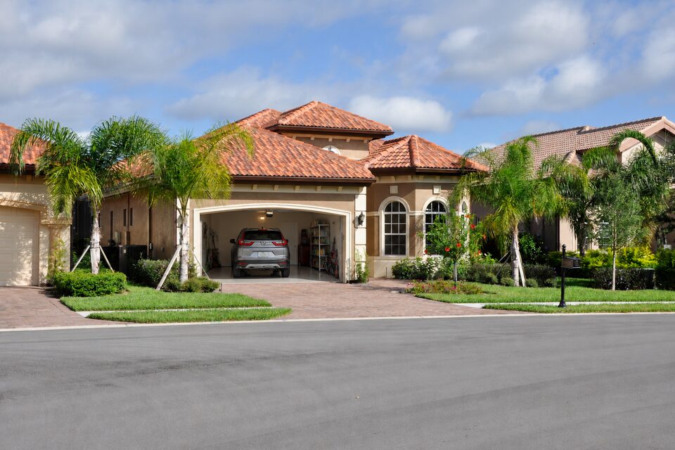 A car stored in the garage of a Florida winter residence among palm trees